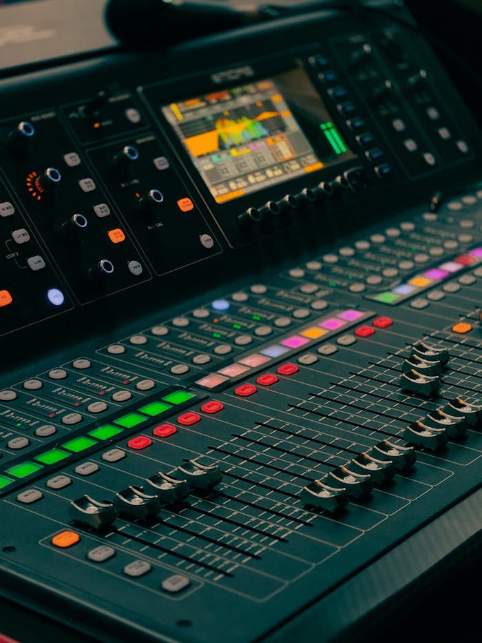 Detailed view of a professional audio mixing console with colorful controls and display.